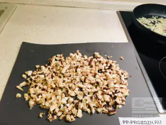 Шаг 3: В сковороду с растопленным сливочным маслом добавьте лук. Пока лук обжаривается до мягкости, нарежьте мелкими кубиками шампиньоны.