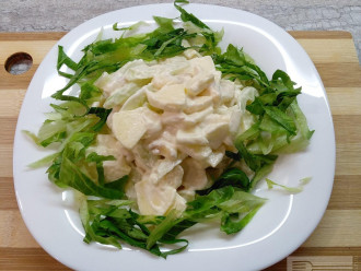 Шаг 7: Выложите салат горкой посередине тарелки и украсьте вокруг нарезанными салатными листьями.