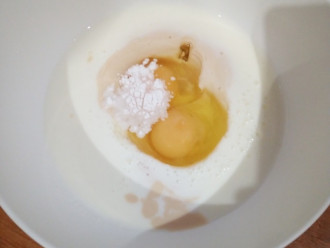 Шаг 2: В миску влейте кефир, разбейте яйца, всыпьте подсластитель и разрыхлитель. Взбейте немного миксером.