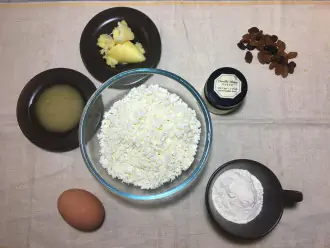 Шаг 1: Для сырников в мультиварке подготовьте продукты: творог, яйцо, мед, муку, изюм и разрыхлитель.