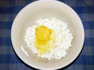 Шаг 2: В глубокую миску с обезжиренным творогом вбейте яйцо.
