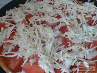 Шаг 6: Смажьте основу для пиццы томатным соусом. Сверху выложите овощи и посыпьте сыром. Накройте пиццу крышкой. И выпекайте еще 10 минут до готовности.