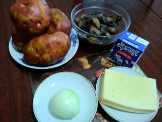 Шаг 1: Подготавьте интредиенты: крупный картофель, грибы, лук, сыр и сливки для жульена в картофельных лодочках.