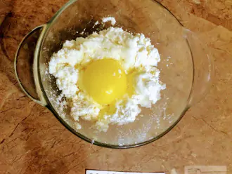 Шаг 2: В глубокую тарелку высыпьте творог и вбейте яйцо.