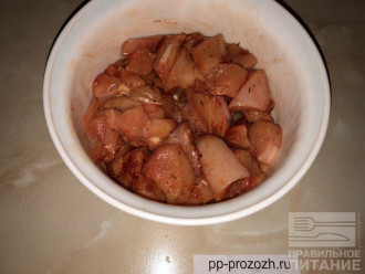 Шаг 2: Нарежьте курицу небольшими кусочками, добавьте специи и соль, перемешайте.