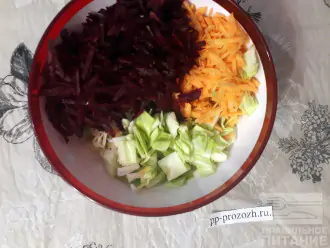 Шаг 3: Мелко нашинкуйте капусту. Сырую свеклу очистите и натрите на крупной терке. Соедините все овощи в салатнике. 
