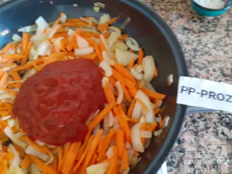 Шаг 4: Лук и морковь пропассеруйте и добавьте томатный соус. Залейте заправку горячей кипячёной водой. Тщательно перемешайте, доведите до кипения.