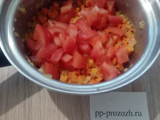 Шаг 5: С помидора снимите кожицу, ошпарив его кипятком. Порежьте и добавьте к овощам. Тушите 5 минут под крышкой.