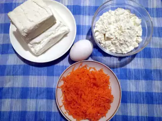 Шаг 1: Подготовьте необходимые для сырников ингредиенты: творог, муку, яйцо и тертую на мелкой терке морковь среднего размера.