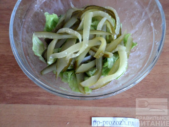 Шаг 6: Аккуратно порвите на кусочки листья салата и положите в отдельную тарелку, смешайте с заправкой, добавьте огурцы.