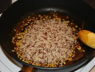 Шаг 4: Выложите рис и пожарьте его в масле и специях минуты 3 до потрескивания.