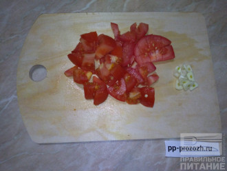 Шаг 5: Нарежьте кубиками помидор и положите в сковороду к остальным овощам. Посолите, поперчите. Нарежьте чеснок.