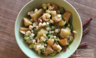 Шаг 6: Остывшие печеные яблоки, банан и киви выложите в салатник и перемешайте. Фруктовый салат готов.