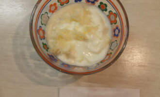Шаг 3: Приготовьте соус. Для этого в йогурт добавьте измельченный чеснок.