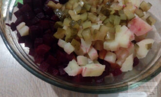Шаг 6: Солёные огурцы порежьте мелким кубиком и также отправляйте в салатник. Вместо огурцов можно взять квашенную капусту, также 100-120 грамм.