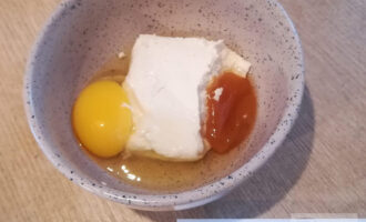 Шаг 5: В это время включите духовку на 180 градусов. 
Приготовьте начинку из оставшегося творога, яйца, мёда, ванилина. Все ингредиенты смешайте до однородности.