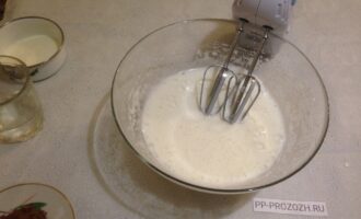 Шаг 6: К белкам добавьте сливки с желатином и взбейте при низкой скорости миксера. Достаньте корж из духовки, выньте из формы и дайте ему остыть.