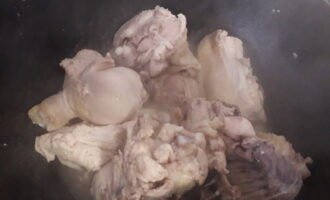 Шаг 3: Поставьте казан на плиту, влейте растительное масло и положите кусочки курицы. Курица выделит сок и начнет тушиться.